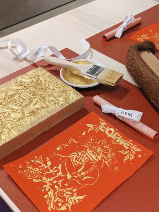 Wood block printing of an ox in gold ink on red paper for Lunar New Year.