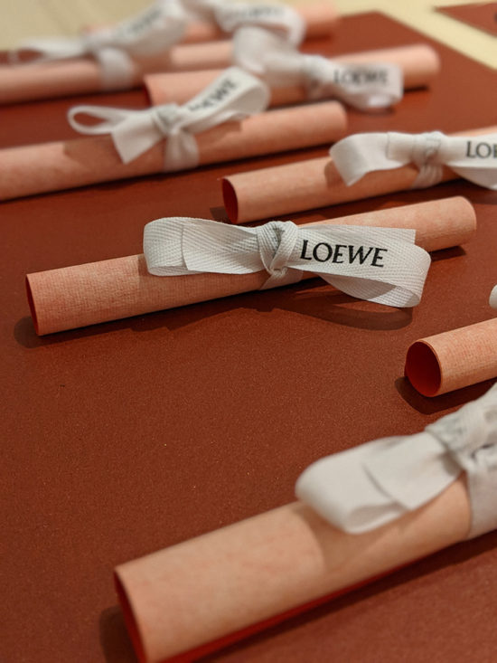 Close up view of rolled red paper sheets, each wrapped with a white ribbon.